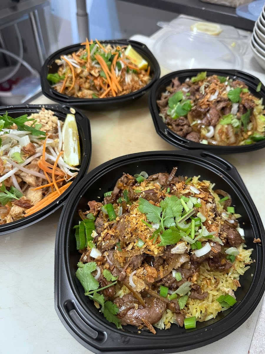 Plusieurs bols à emporter : pad thaï aux pousses et cacahuètes, bœuf sauté aux oignons.